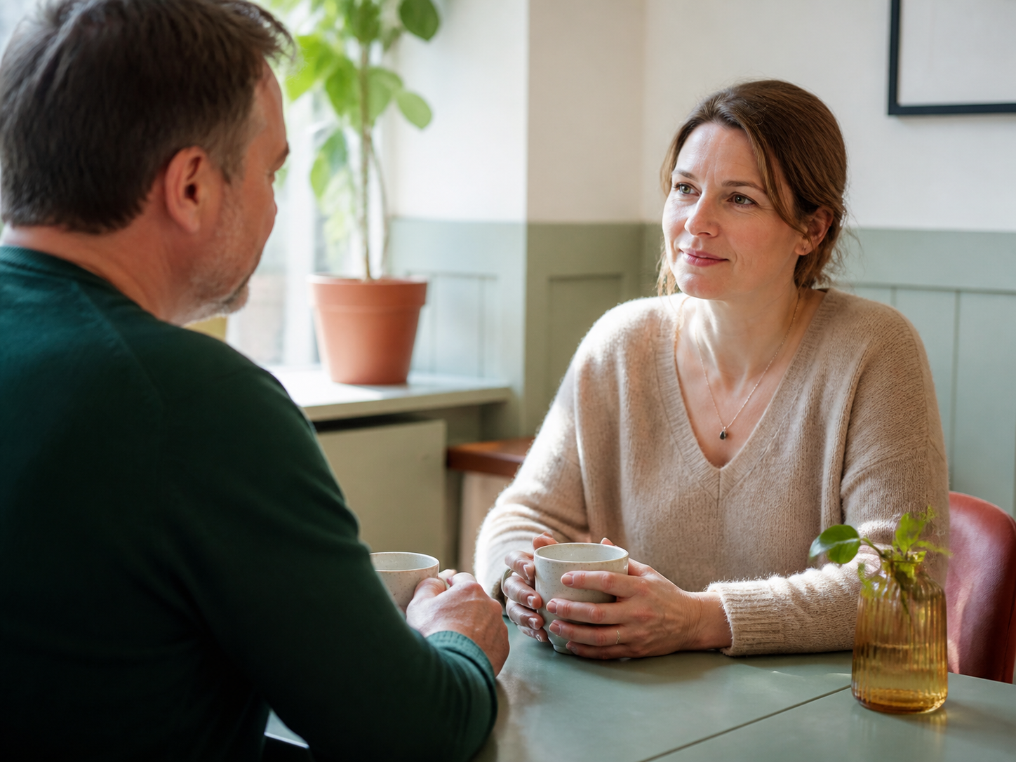 To personer i en rolig og fortrolig samtale over kaffe